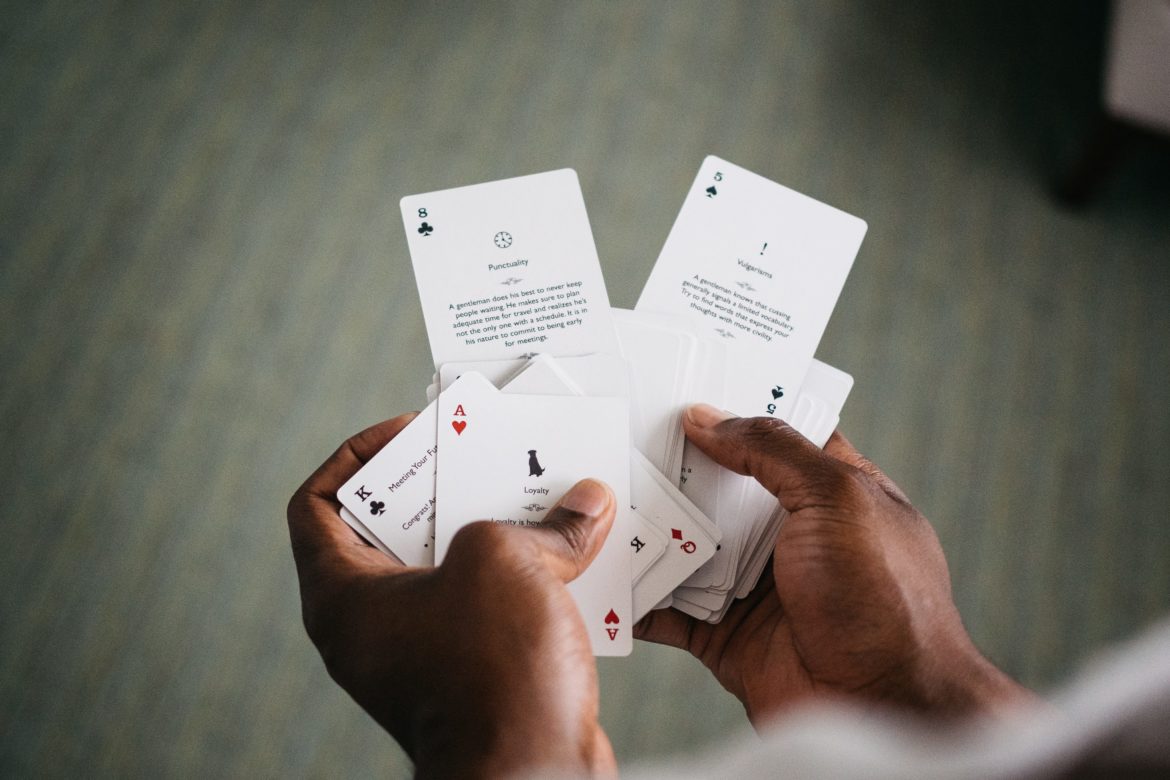 Ein Close up von von zwei Händen die Spielkarten in der Händen hält.