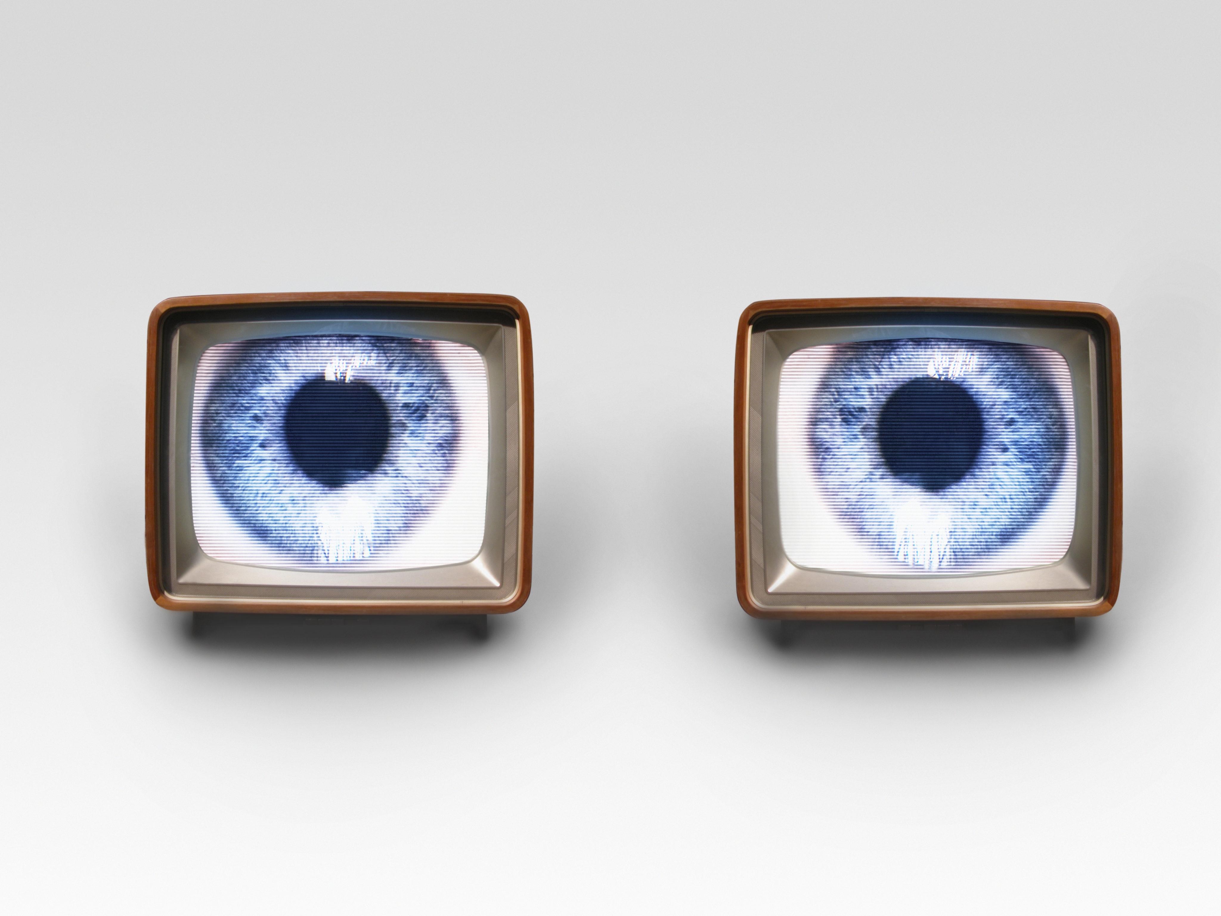 Zwei alte Fernseher mit einem Auge als Bild