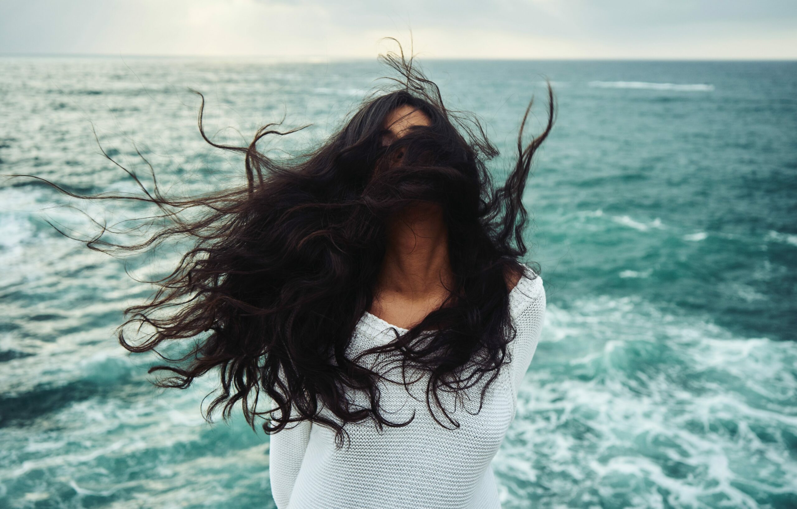 Gesichtspflege_Frau mit langen Haaren am Meer