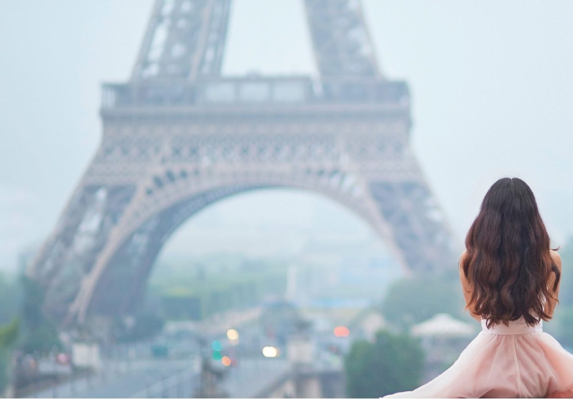 Eisenmangel Ursachen: Frau in einem rosanen Kleid blickt auf den Eiffelturm.