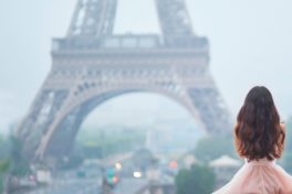 Eisenmangel Ursachen: Frau in einem rosanen Kleid blickt auf den Eiffelturm.