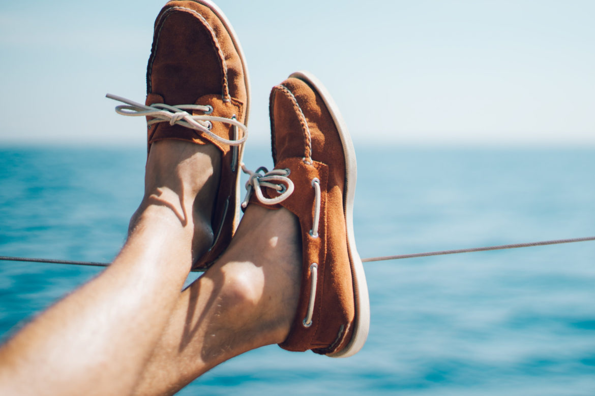 Ausgestreckte Beine mit Schuhen auf einem Schiff