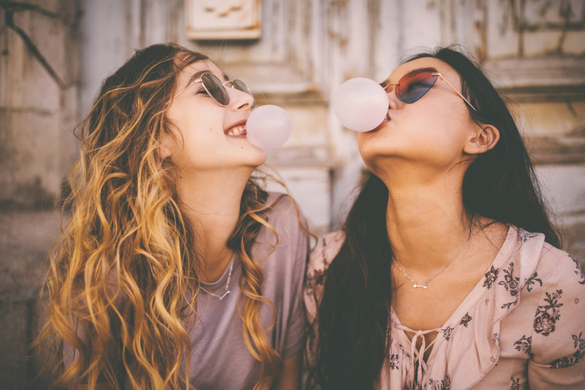 Zwei Mädchen machen Kaugummiblasen mit Kaugummi