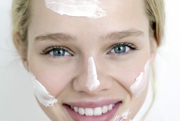 Gesunde Haut: Gesicht einer Frau mit Cremeklecksen