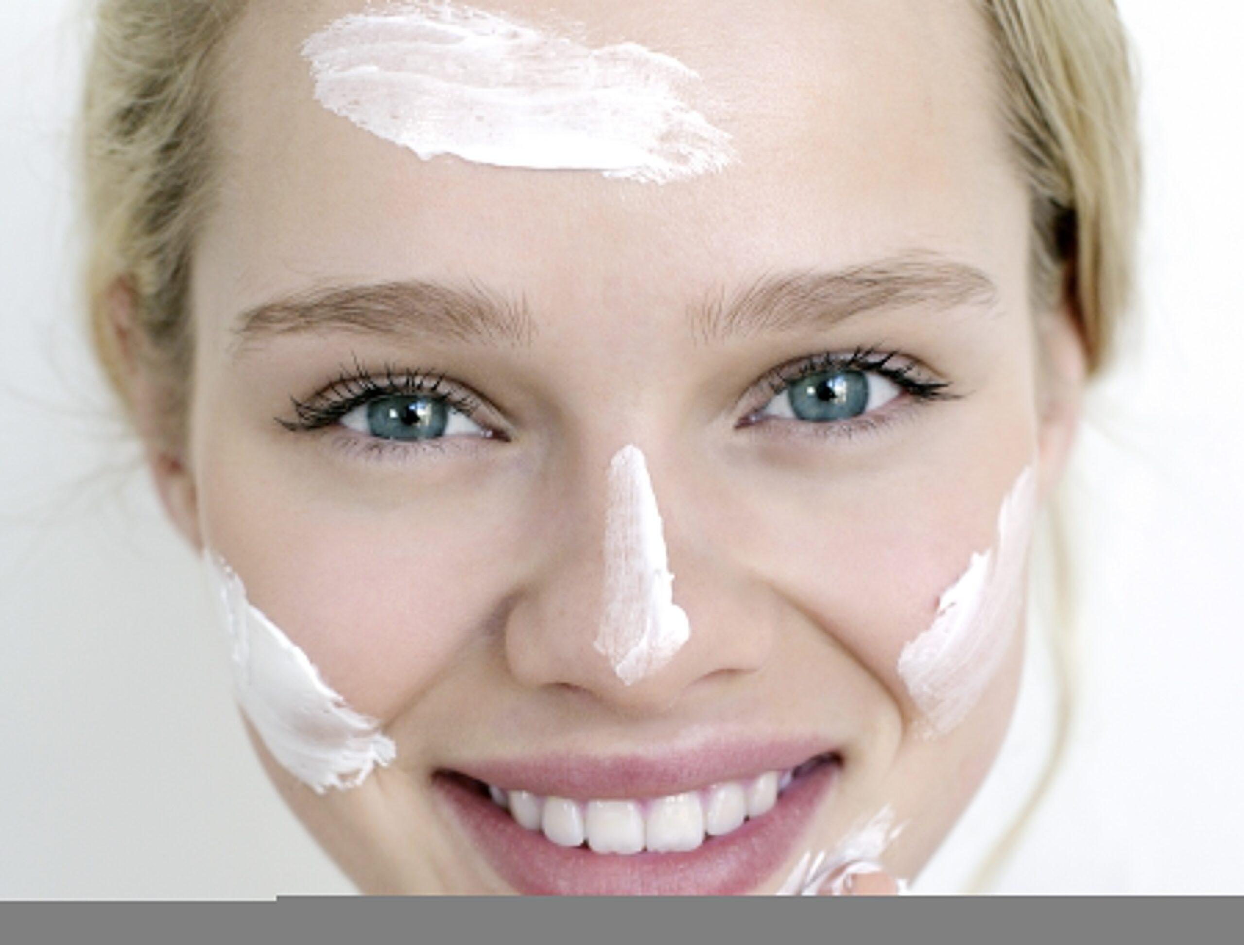 Gesunde Haut: Gesicht einer Frau mit Cremeklecksen
