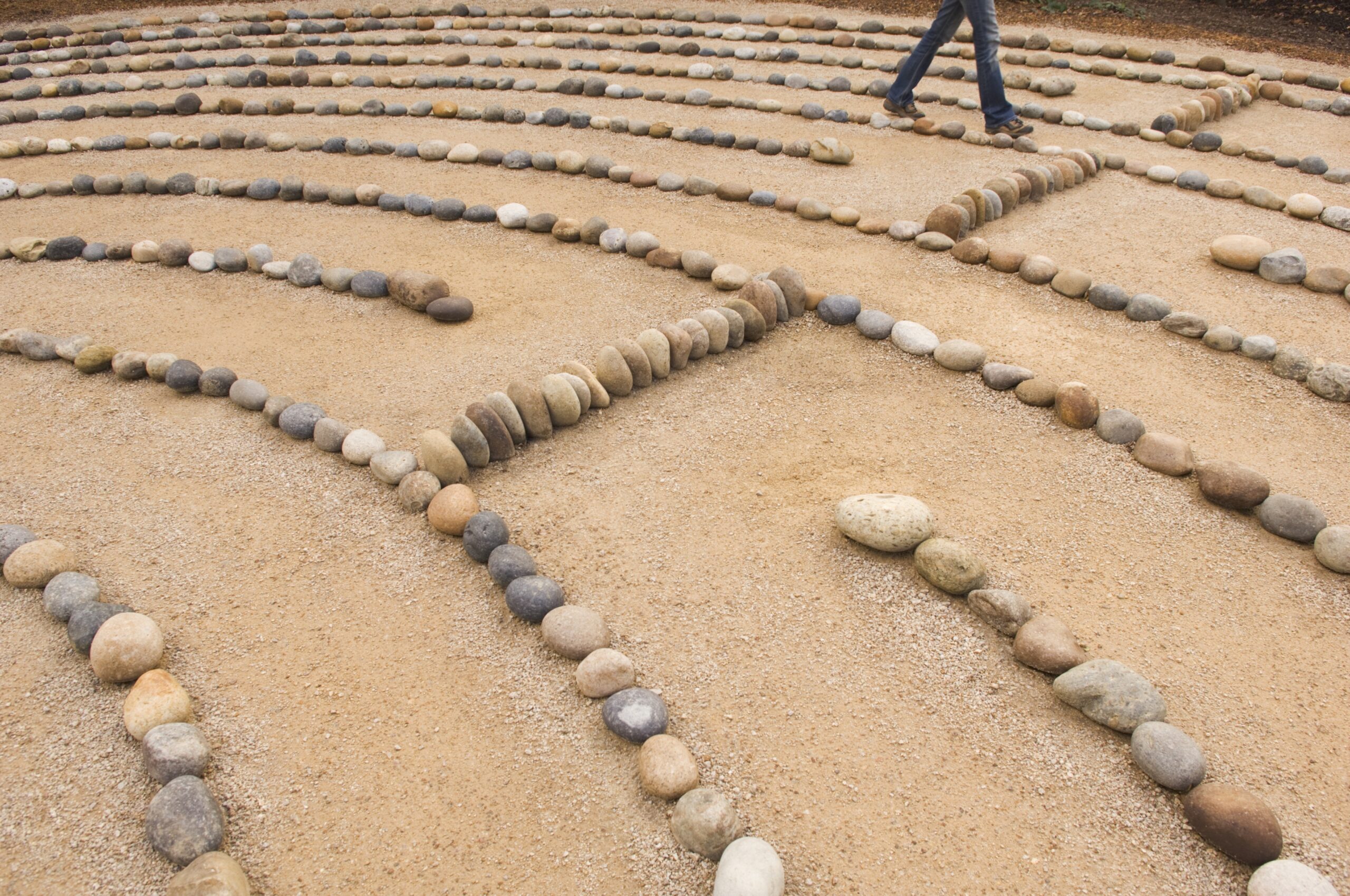 Labyrinth mit Steinen auf Sand - Eierstockkrebs Achtung Alarmsignale