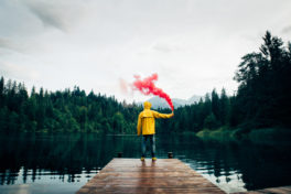 Ein Mann steht auf dem Steg an einem See mit einer Rauchfackel