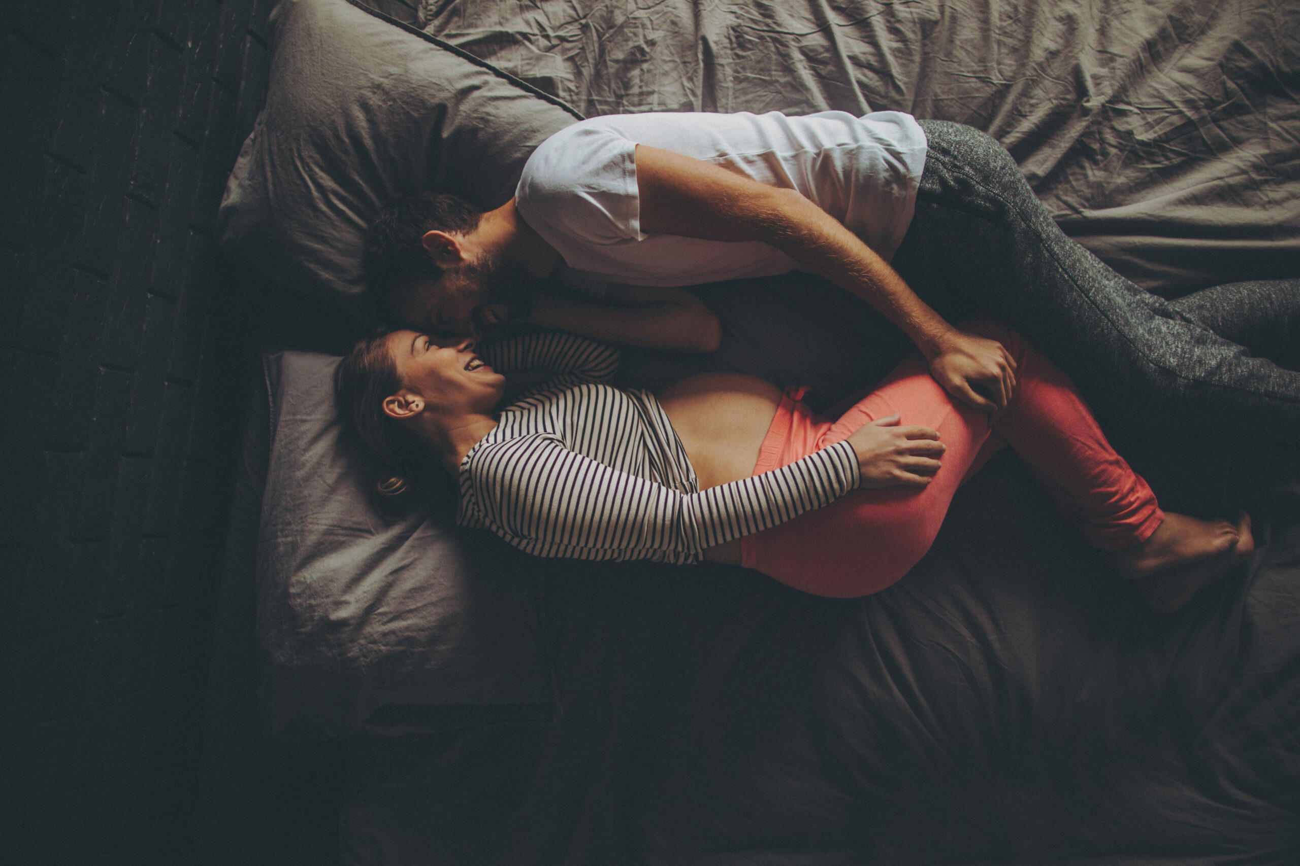 Ein junges Paar liegt auf dem Bett und kuschelt