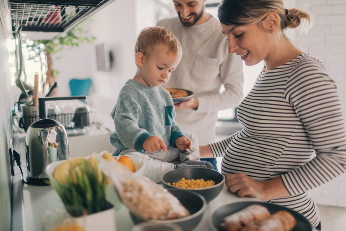 Mann und Frau bereiten Essen mit Kind