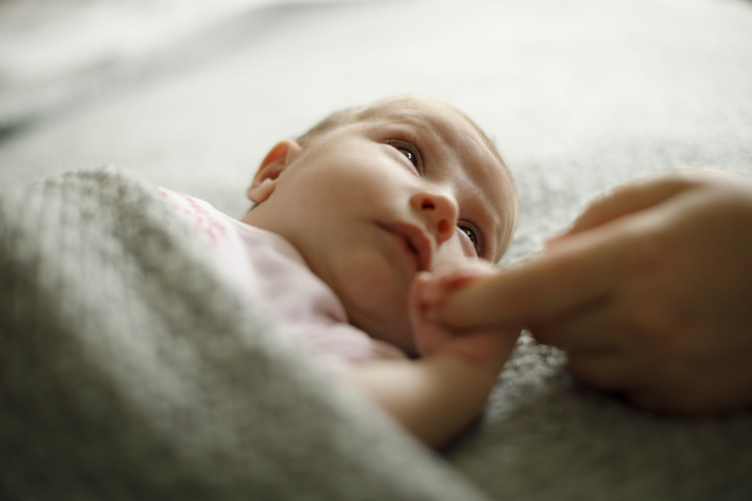 Neugeborenes hält Finger
