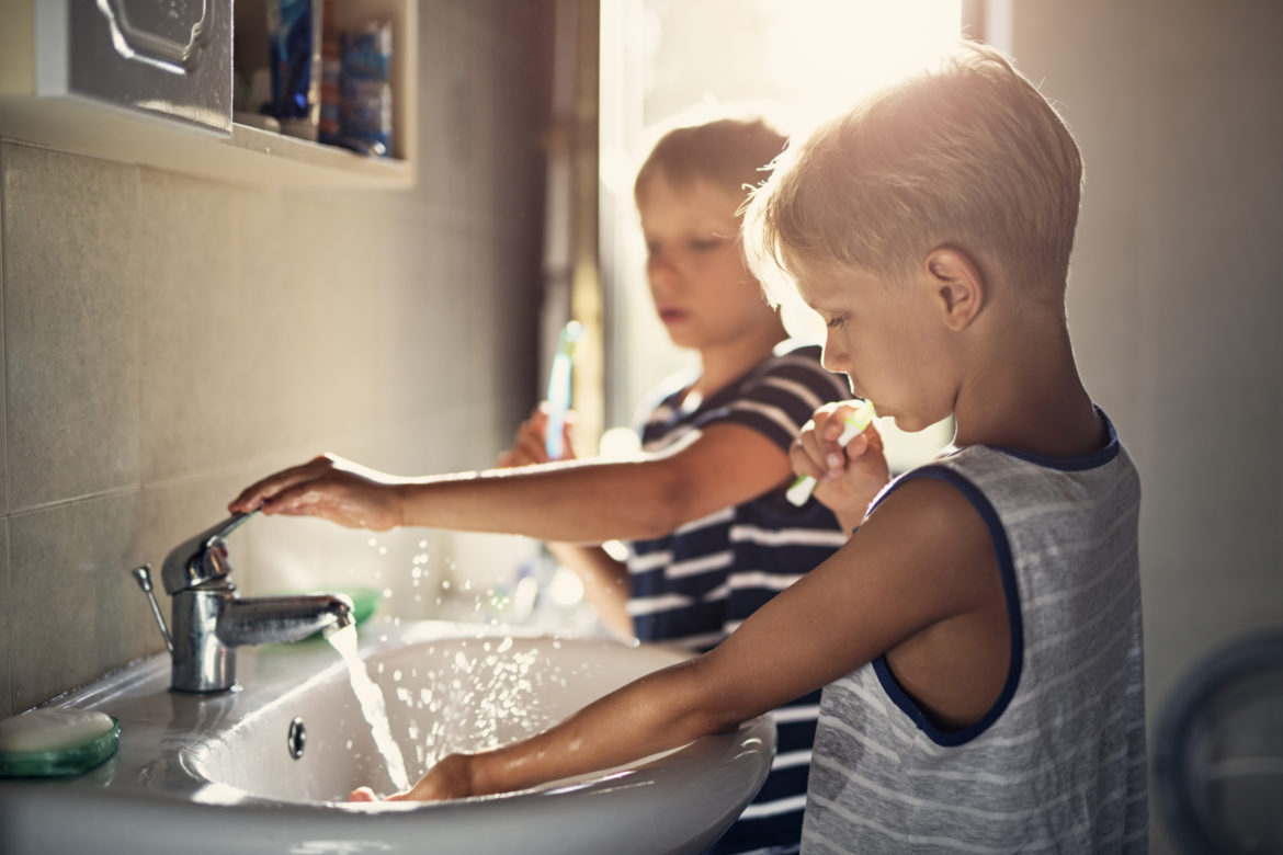 Zwei Jungs putzen sich die Zähne am Waschbecken