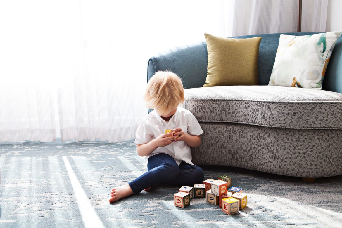 Stottern bei Kindern: Kind spielt vor Sofa