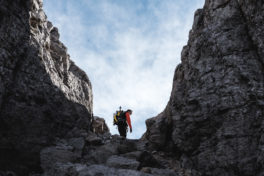 Wanderer zwischen zwei Felswänden - Sicher unterwegs in den Bergen