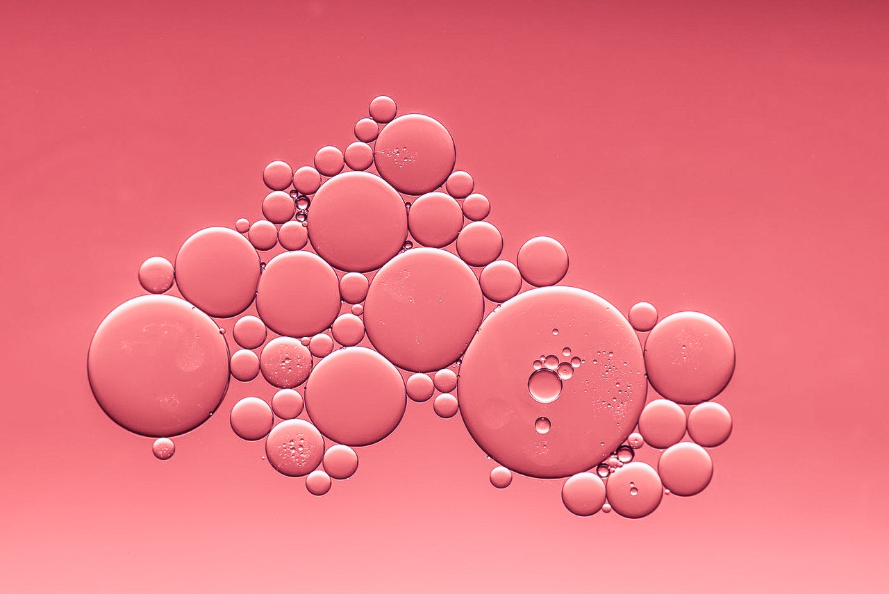 Luftblasen in Wasser in Petrischale pink.