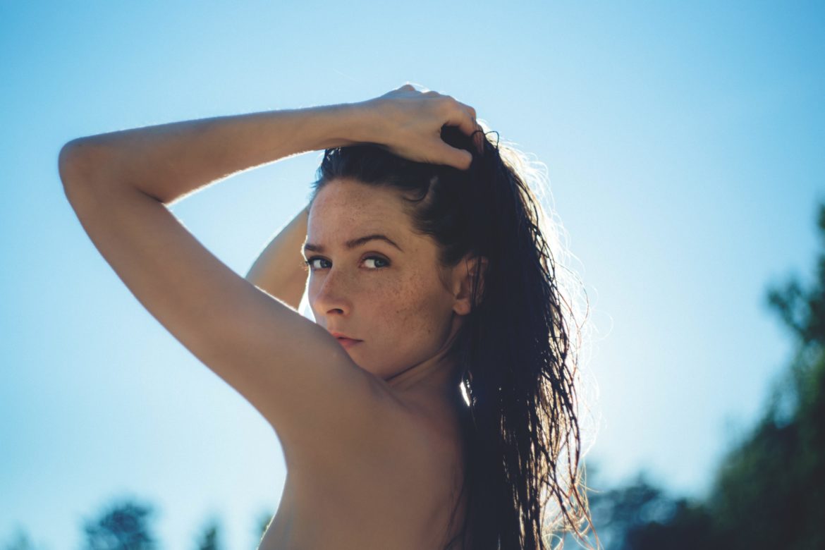 Frau im Sommer mit nassen Haaren in der Sonne. - Haut