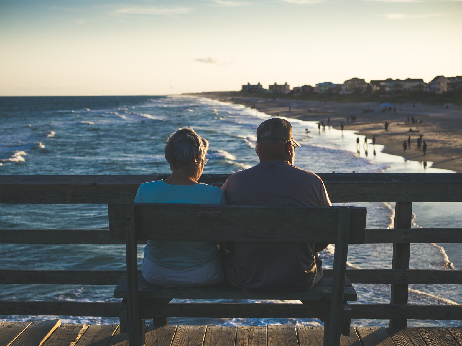 Älteres Paar auf einer Bank am Meer und Strand