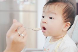 Asiatisches Baby wird gefüttert