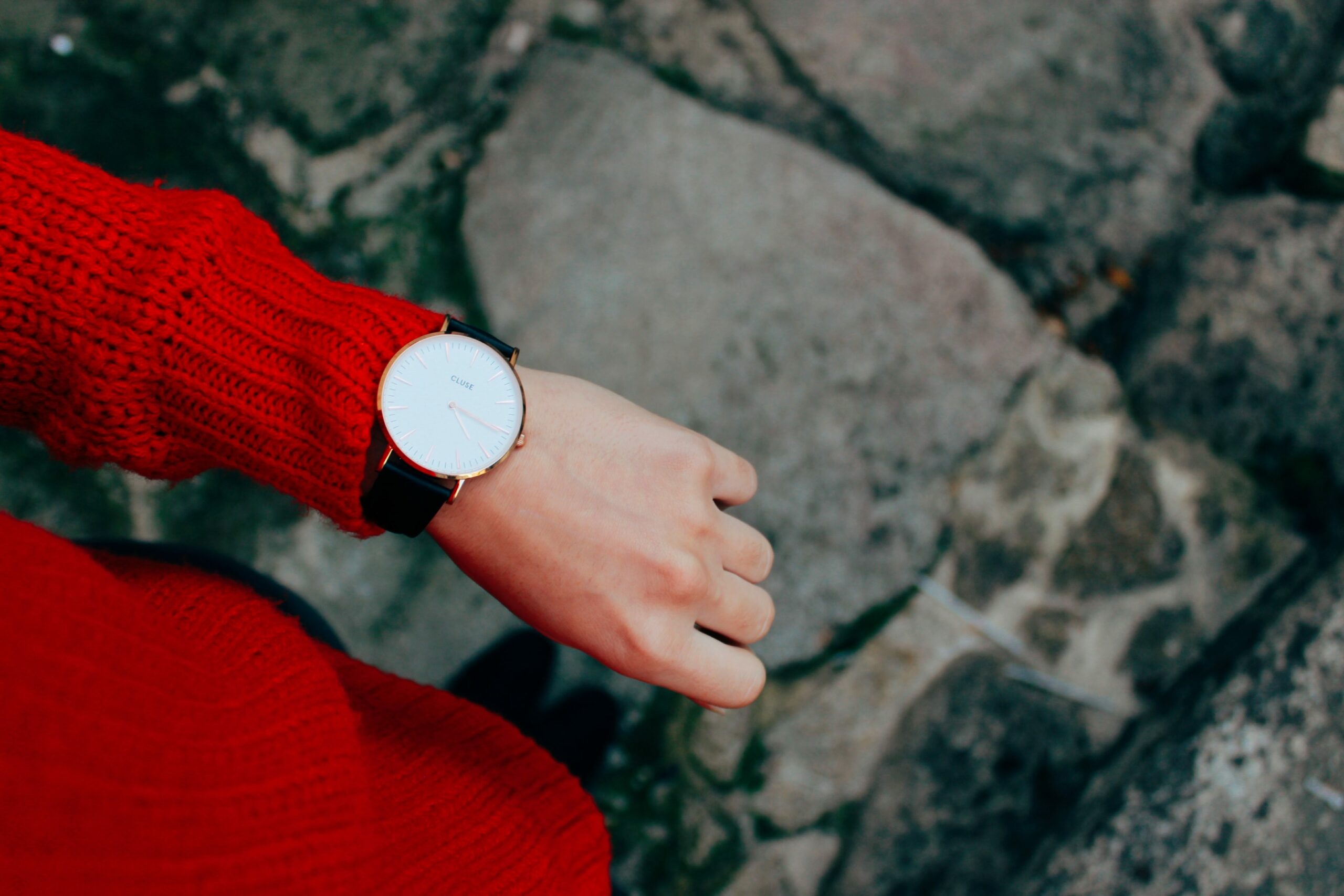 Frau mit rotem Strickpullover und Armbanduhr
