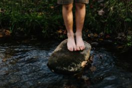 Beine auf Stein in Fluss
