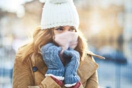 Frau im Winter putzt Nase