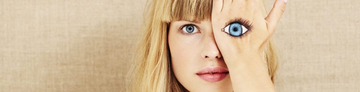 Blonde Frau mit gemaltem Auge auf der Hand