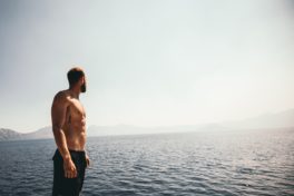 Brust enthaaren: Mann mit freiem Oberkörper in Badehose am Wasser