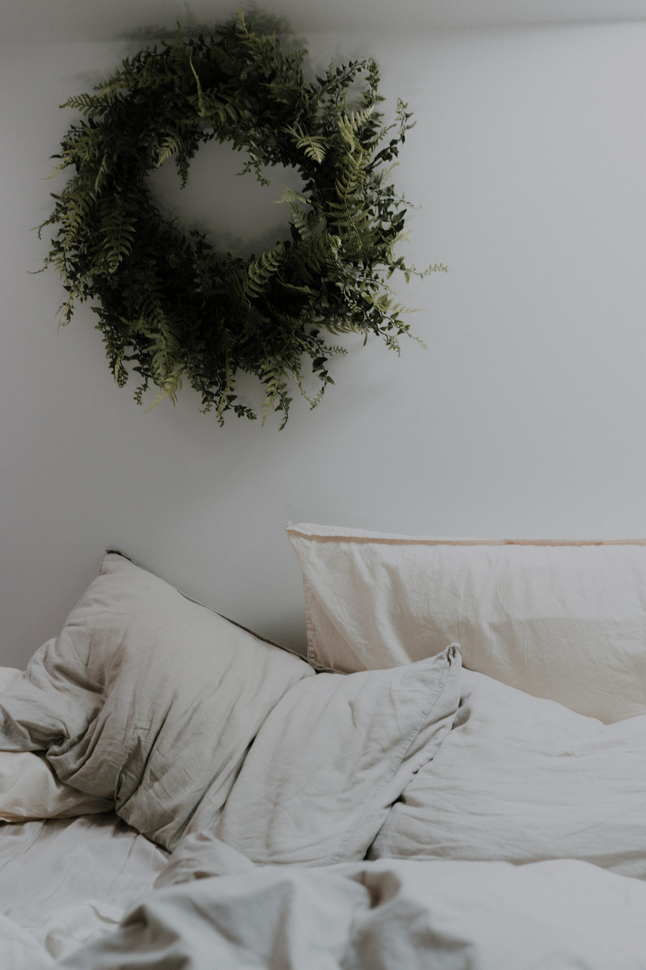 Kissen auf Bett mit grünem Kranz