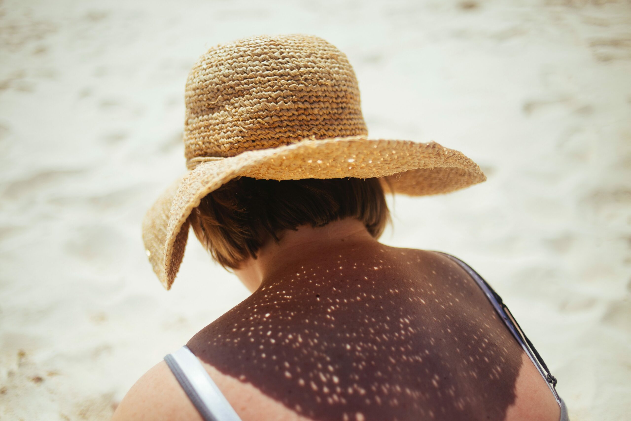 Frau mit Sonnenhut am Strand