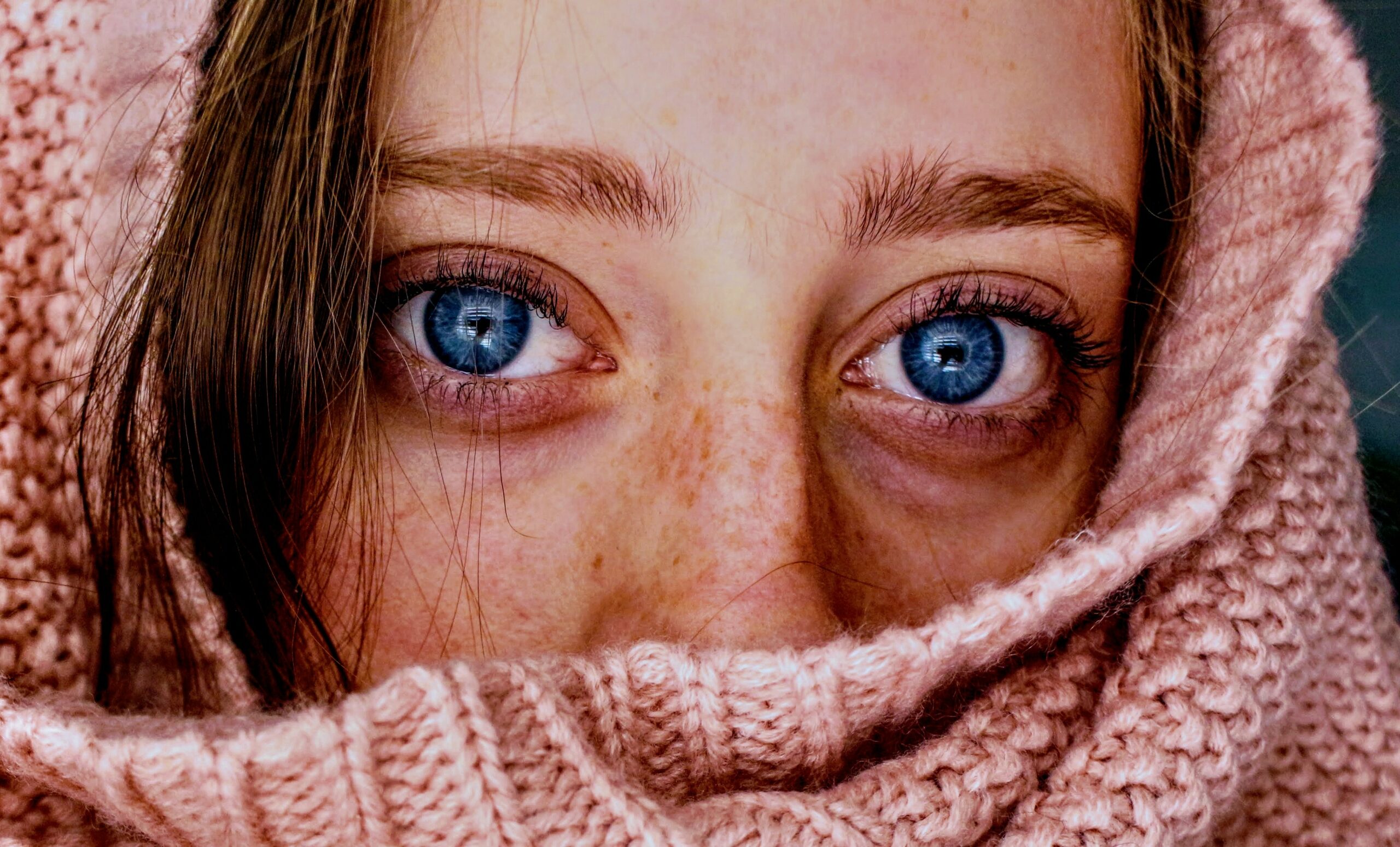Augen entzündet: Frauengesicht mit blauen Augen und Schal