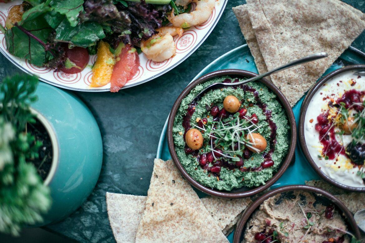 Ernährung Krebsvorsorge: Ein Tisch gedeckt mit mehren kleinen Tellern und mediterranen Gerichten