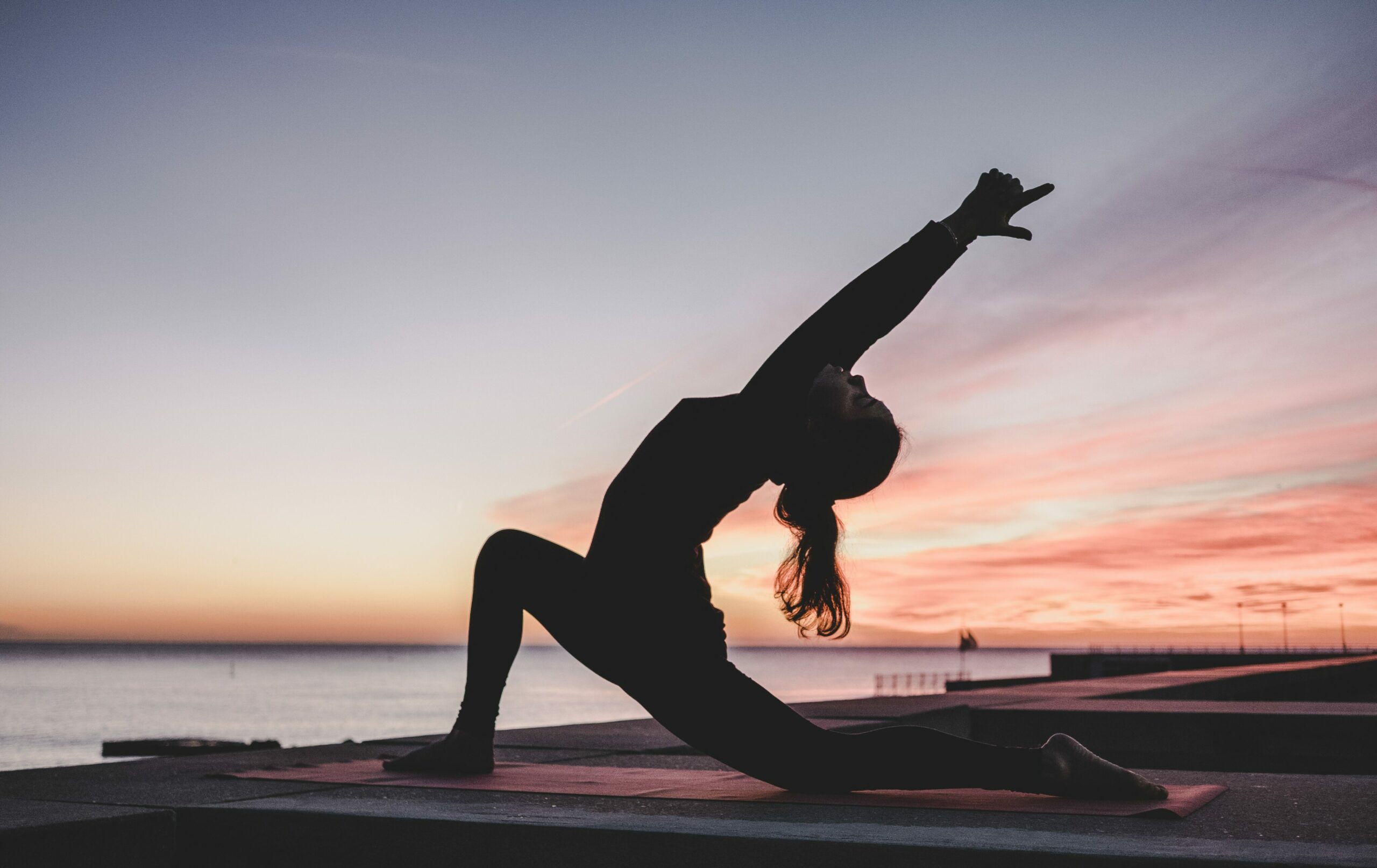 Yin Yoga-Übungen: Frau bei einer Yoga-Pose im Sonnenuntergang
