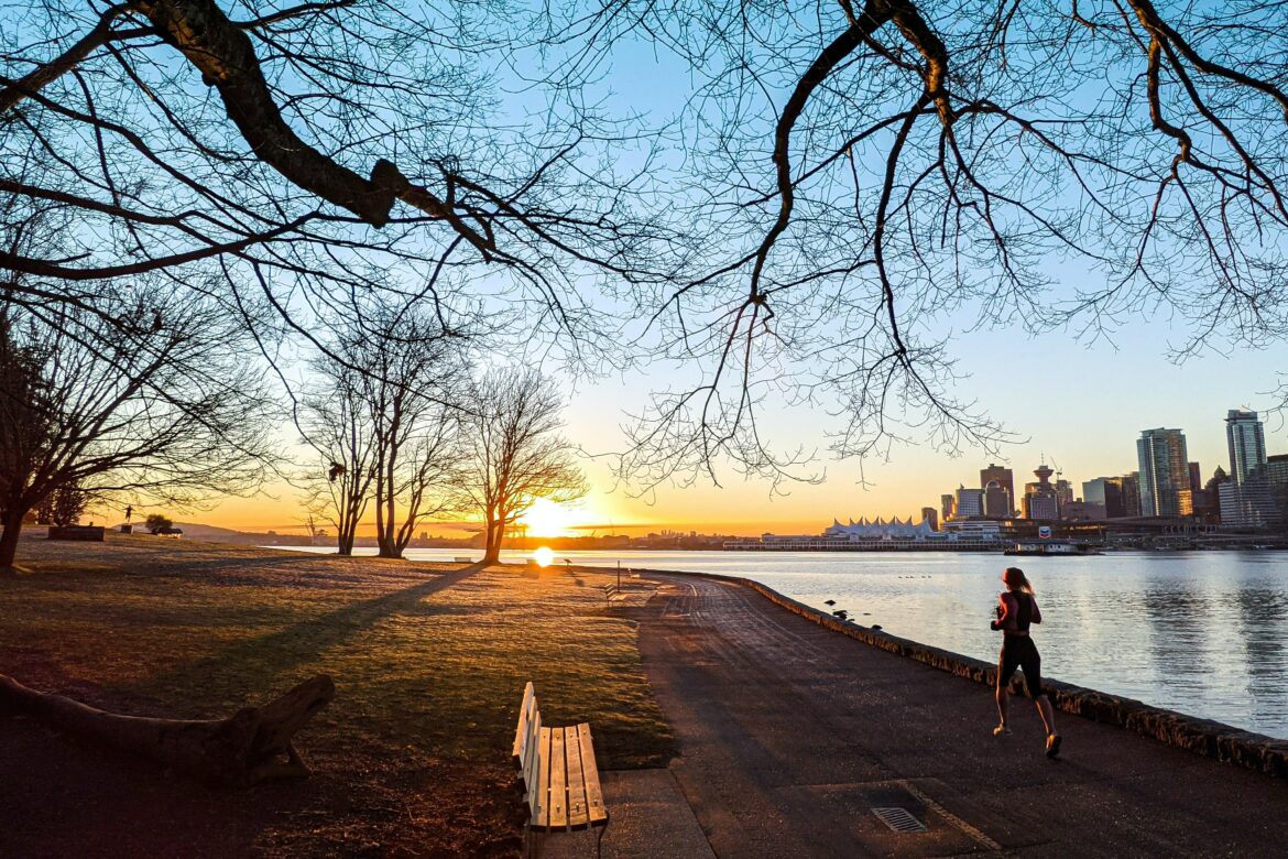 Brustkrebs Bewegung: Frau joggt bei Sonnenuntergang vor Skyline