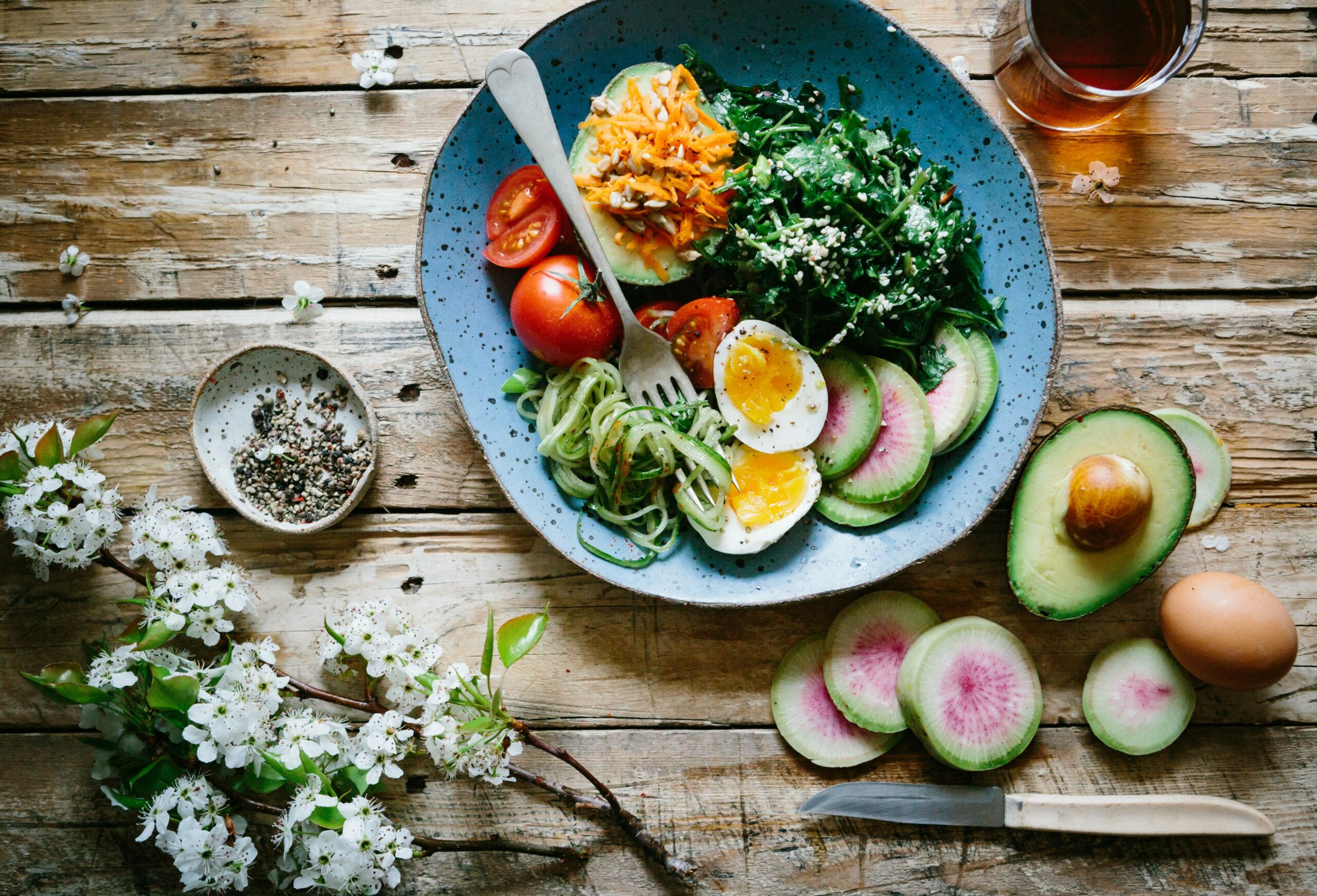 Diabetes durch Ernährung: Gemüse und gekochte Eier in einem blauen Teller, umgeben von Deko