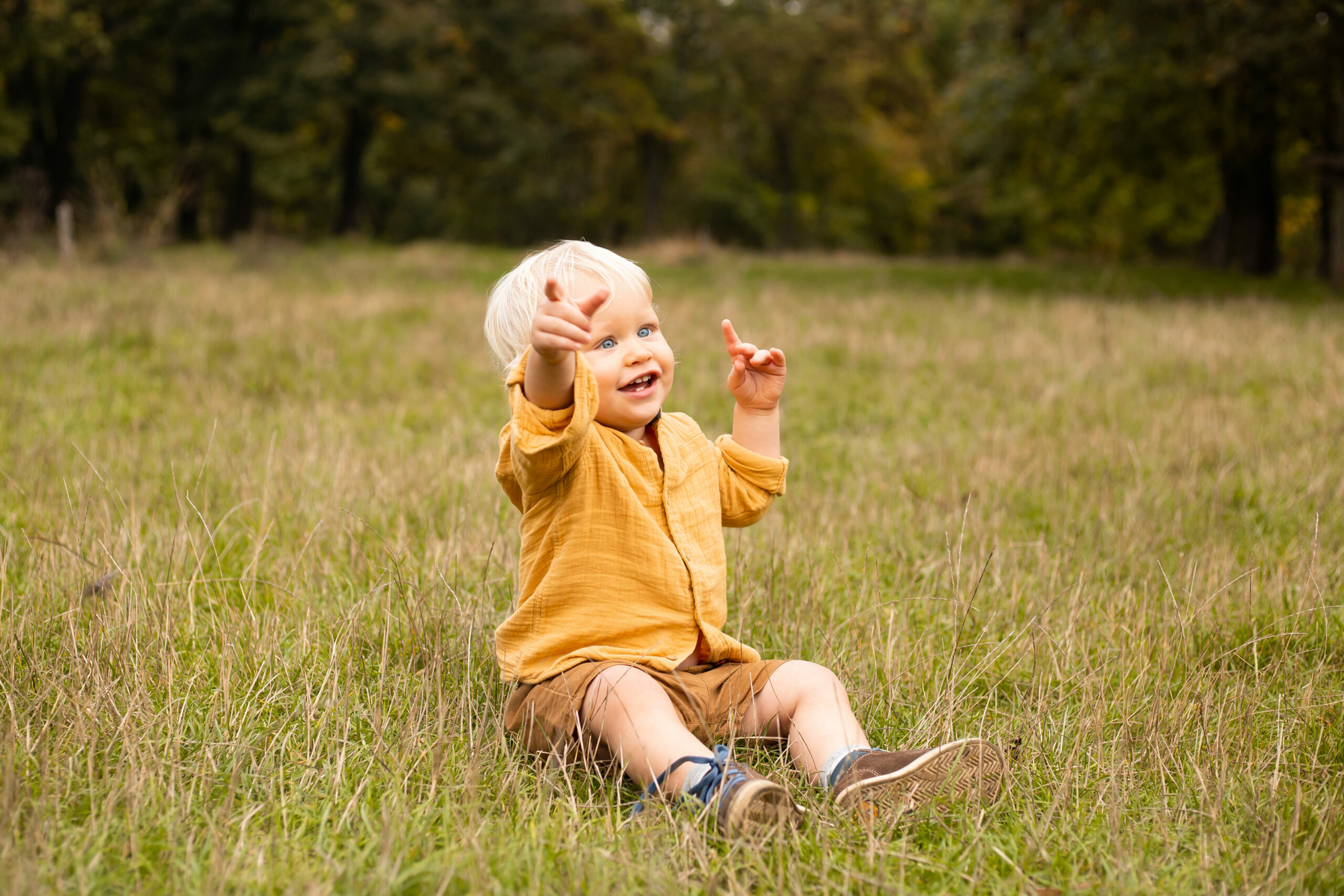 Schielen Kinder: Kleiner schielender Junge sitzt im Gras