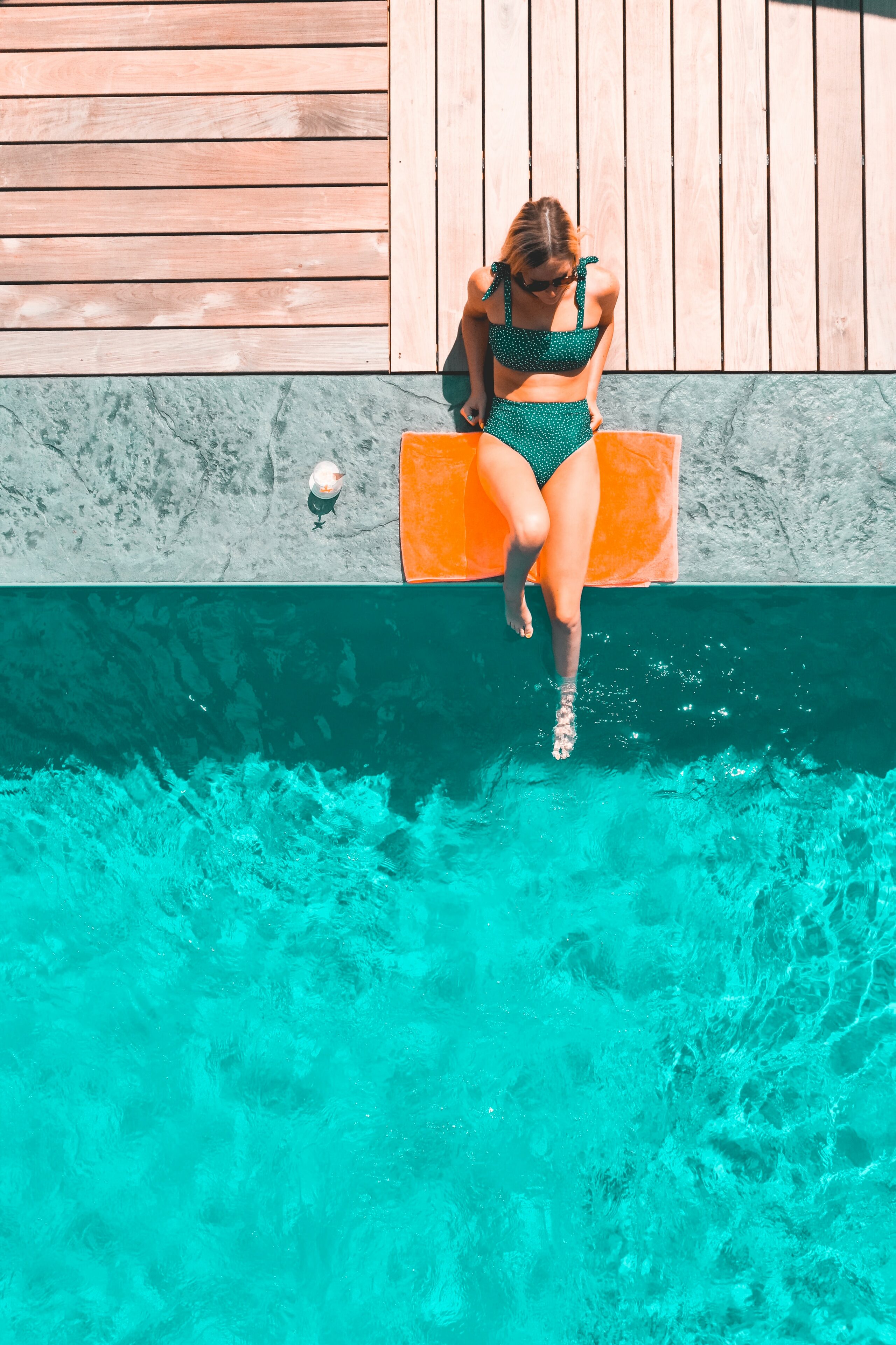 Hautpflege im Sommer: Frau sonnt sich am Pool