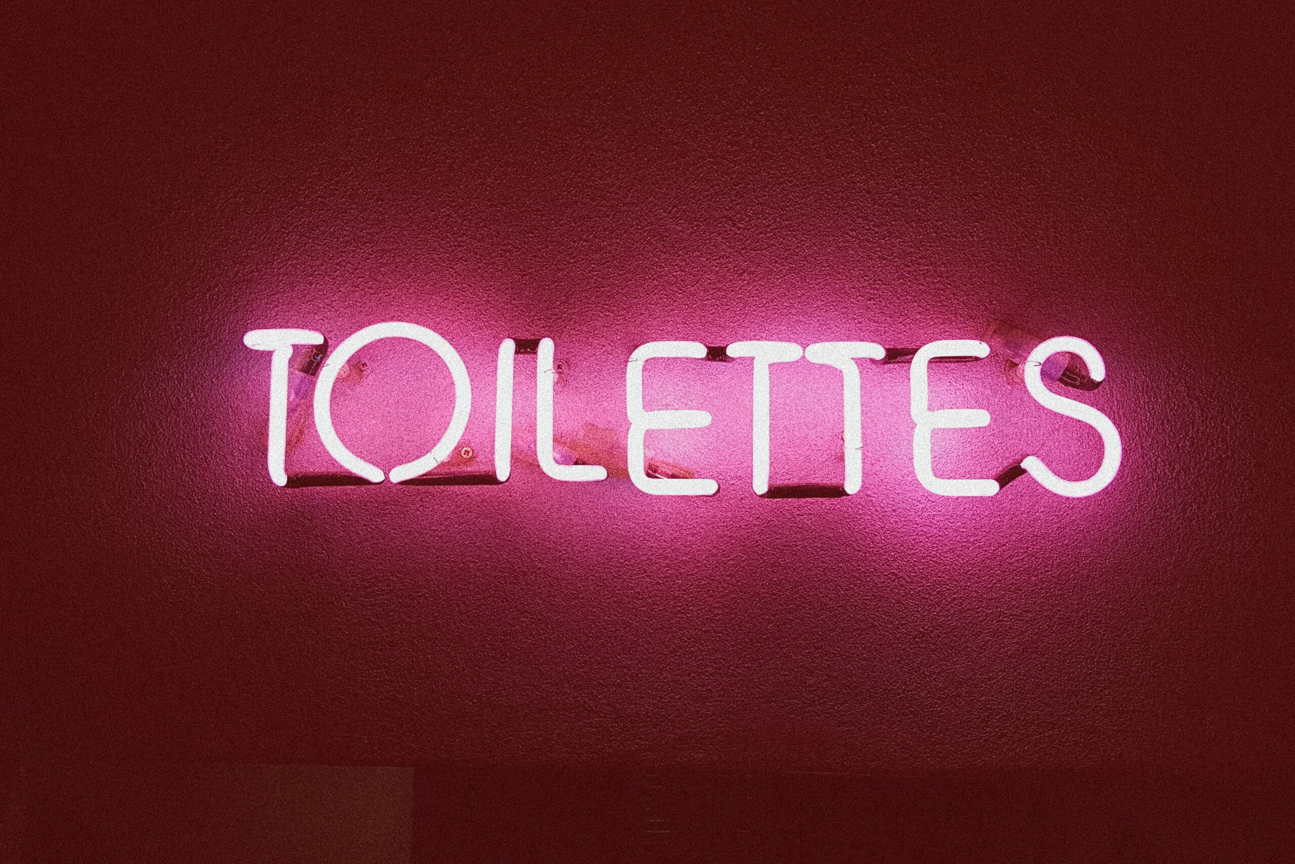 Farbe Urin: Toilettes-Schriftzug in pinker Neonschrift