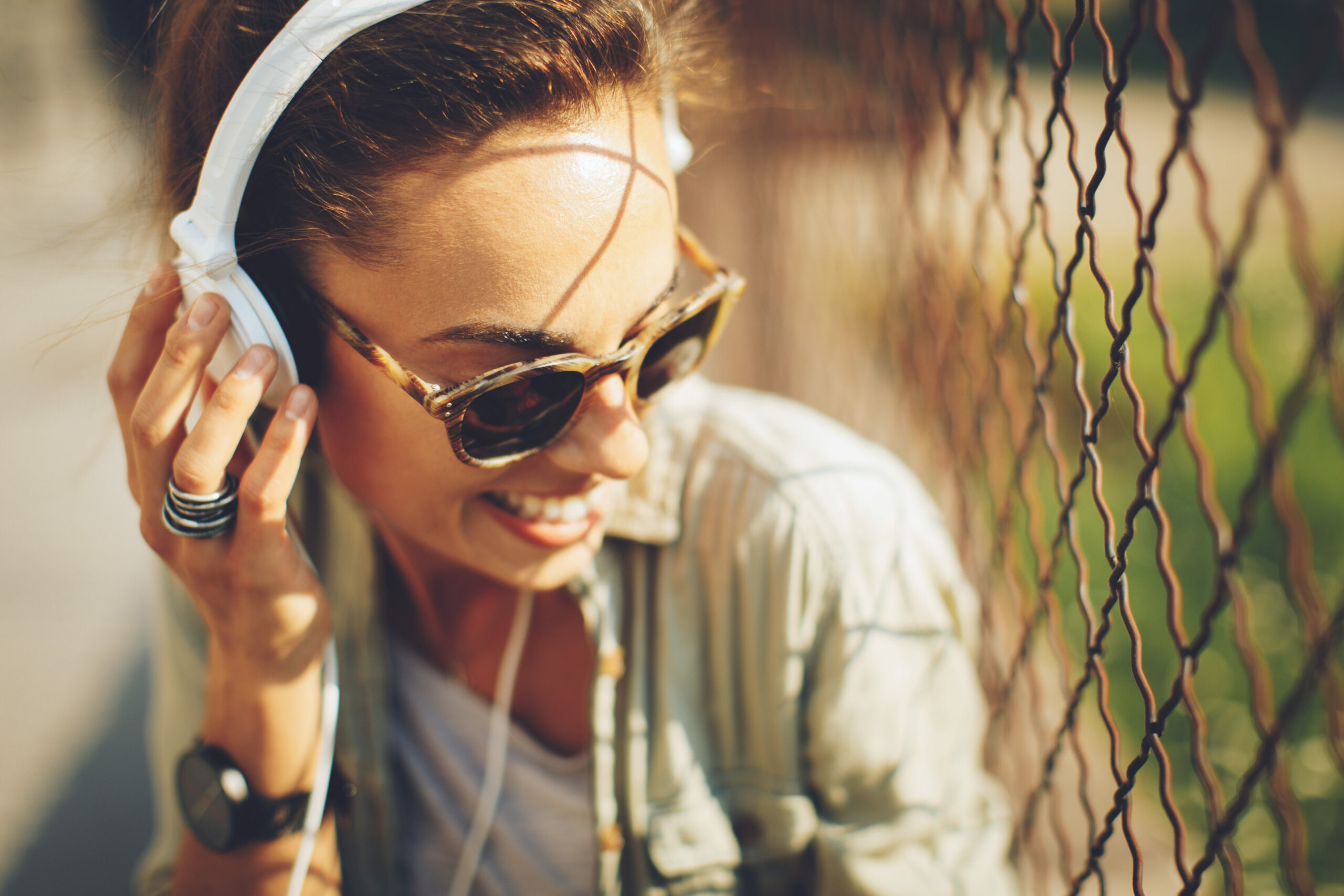 Musik und Gesundheit: junge Frau hört über Kopfhörer Musik und lächelt