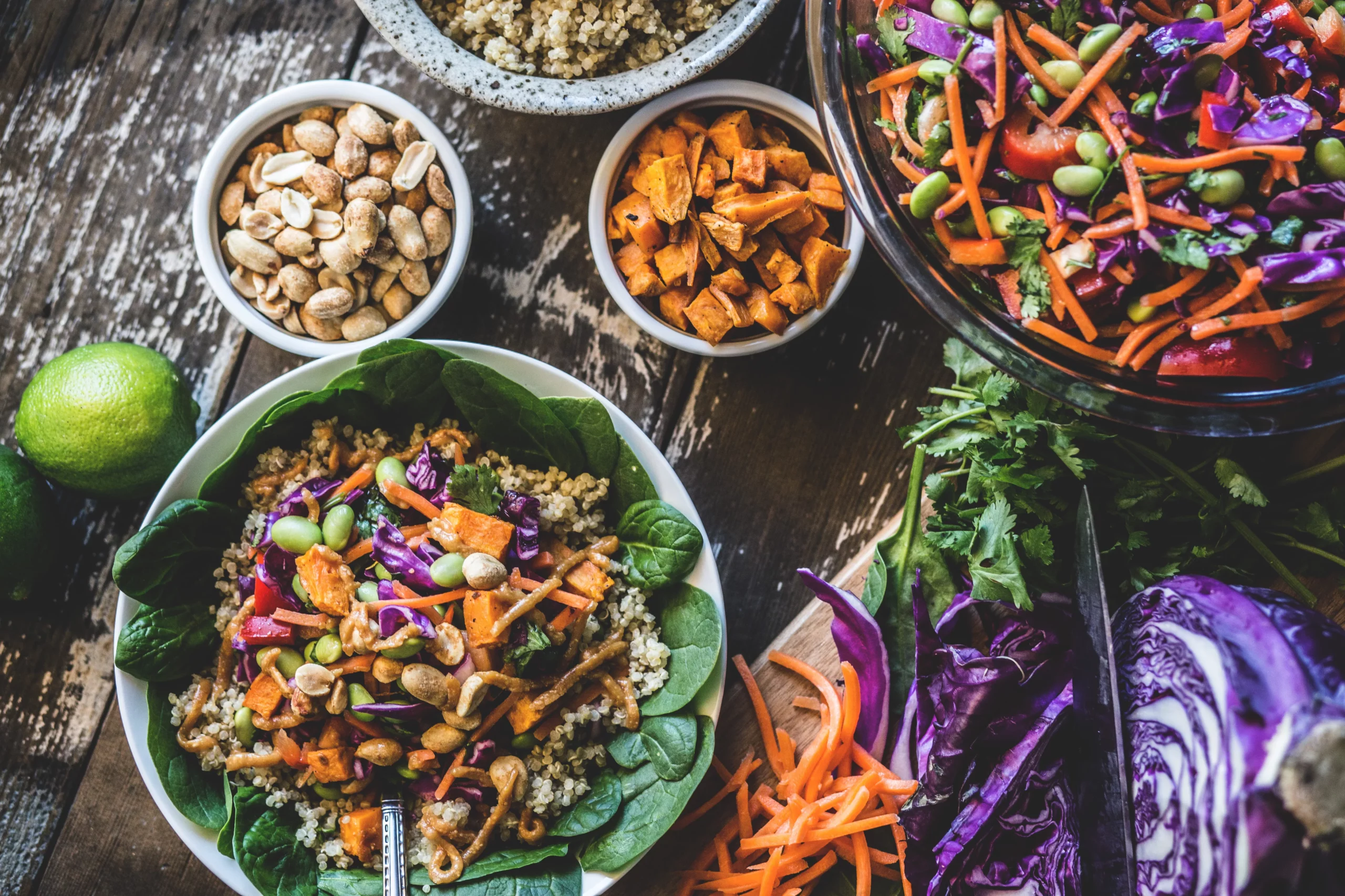 Pflanzenbasierte Ernährung: vegane Bowl und weitere Beilagen auf einem Holztisch