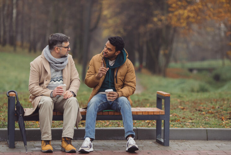 Christliche Seelsorge: Zwei Männer sitzen auf einer Bank und unterhalten sich.