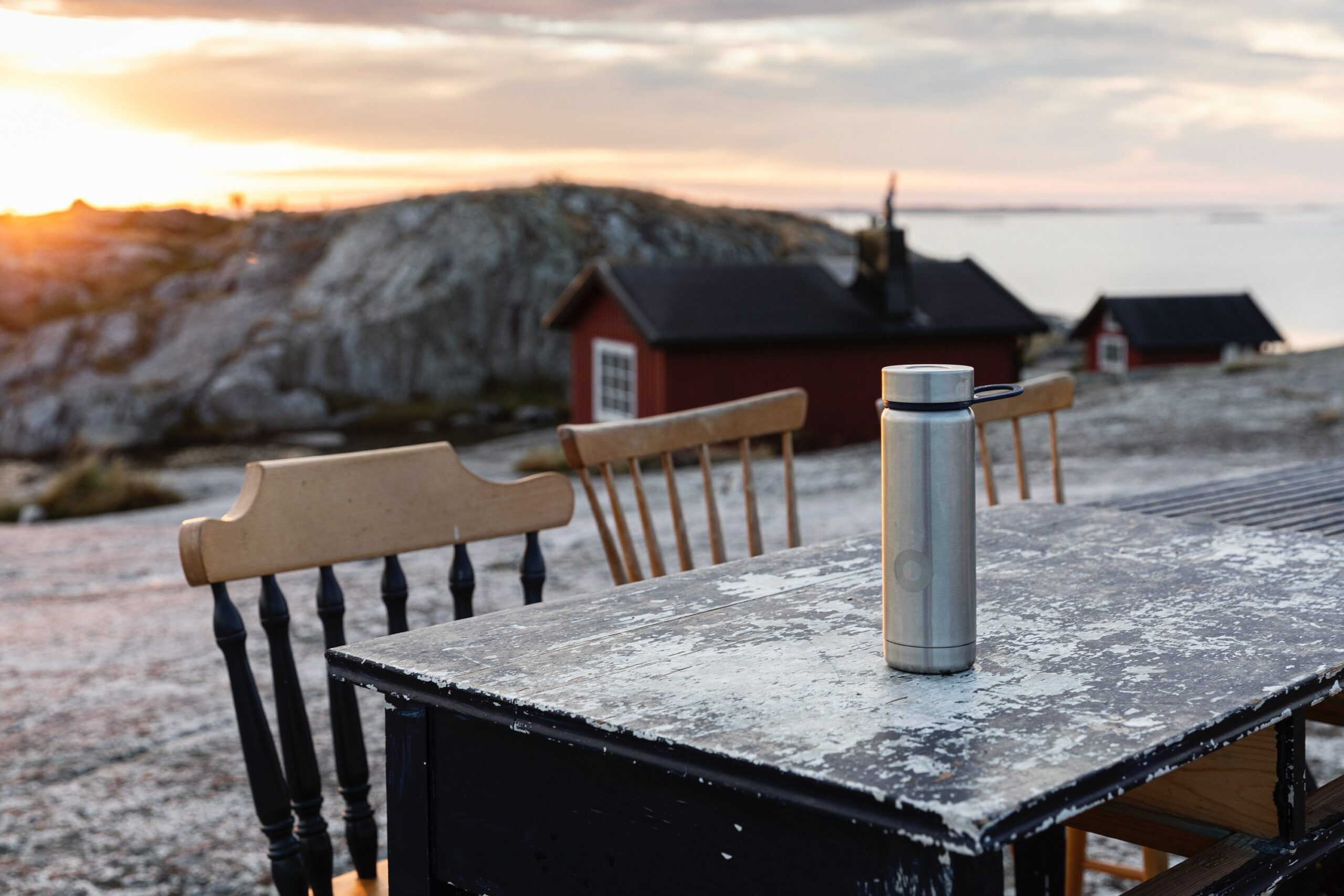 Plastik gefährlich: Edelstahl-Thermosflasche auf dem Tisch im Freien vor einer Bergkulisse