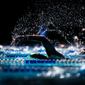 Bewegung Lebenserwartung: Der Arm eines Schwimmers im Freistil ragt aus dem Wasser.
