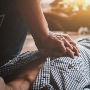 Herzdruckmassage Rhythmus: Reanimation eines Mannes am Boden