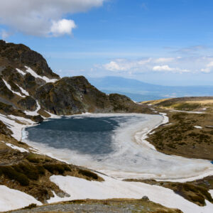 Nierentransplantation Ablauf: zugefrorener, nierenförmiger See in den Bergen