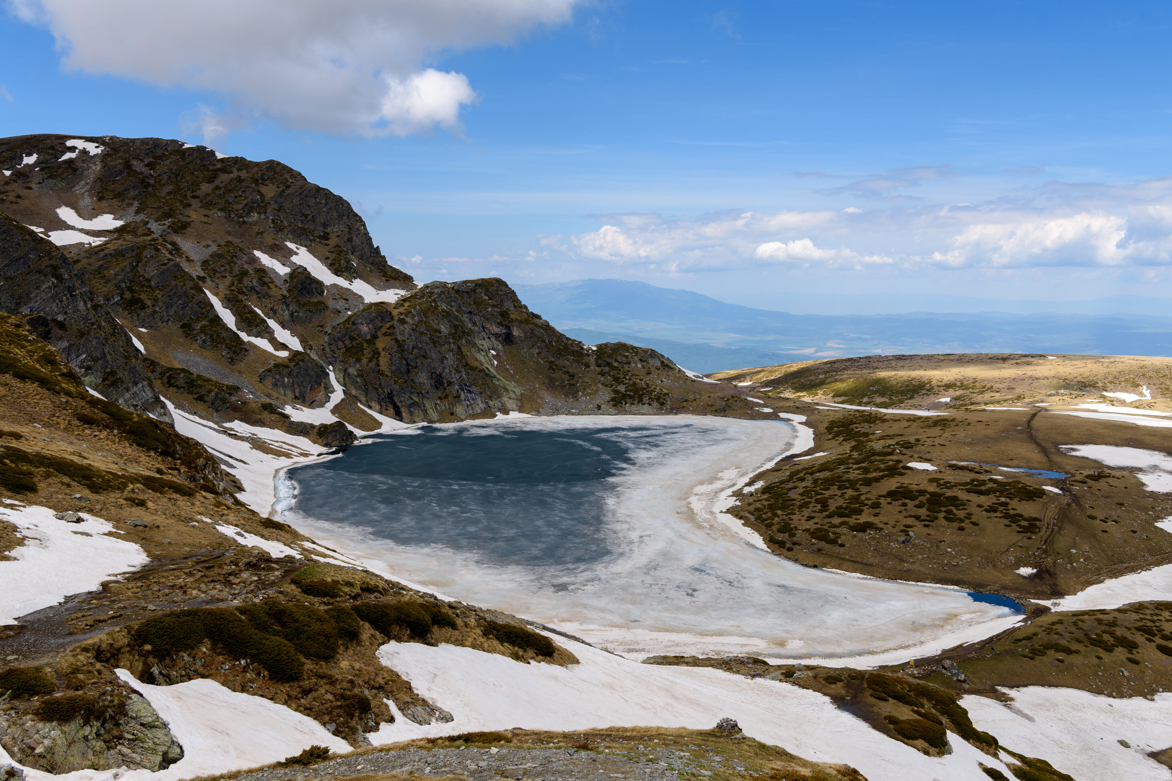 Nierentransplantation Ablauf: zugefrorener, nierenförmiger See in den Bergen