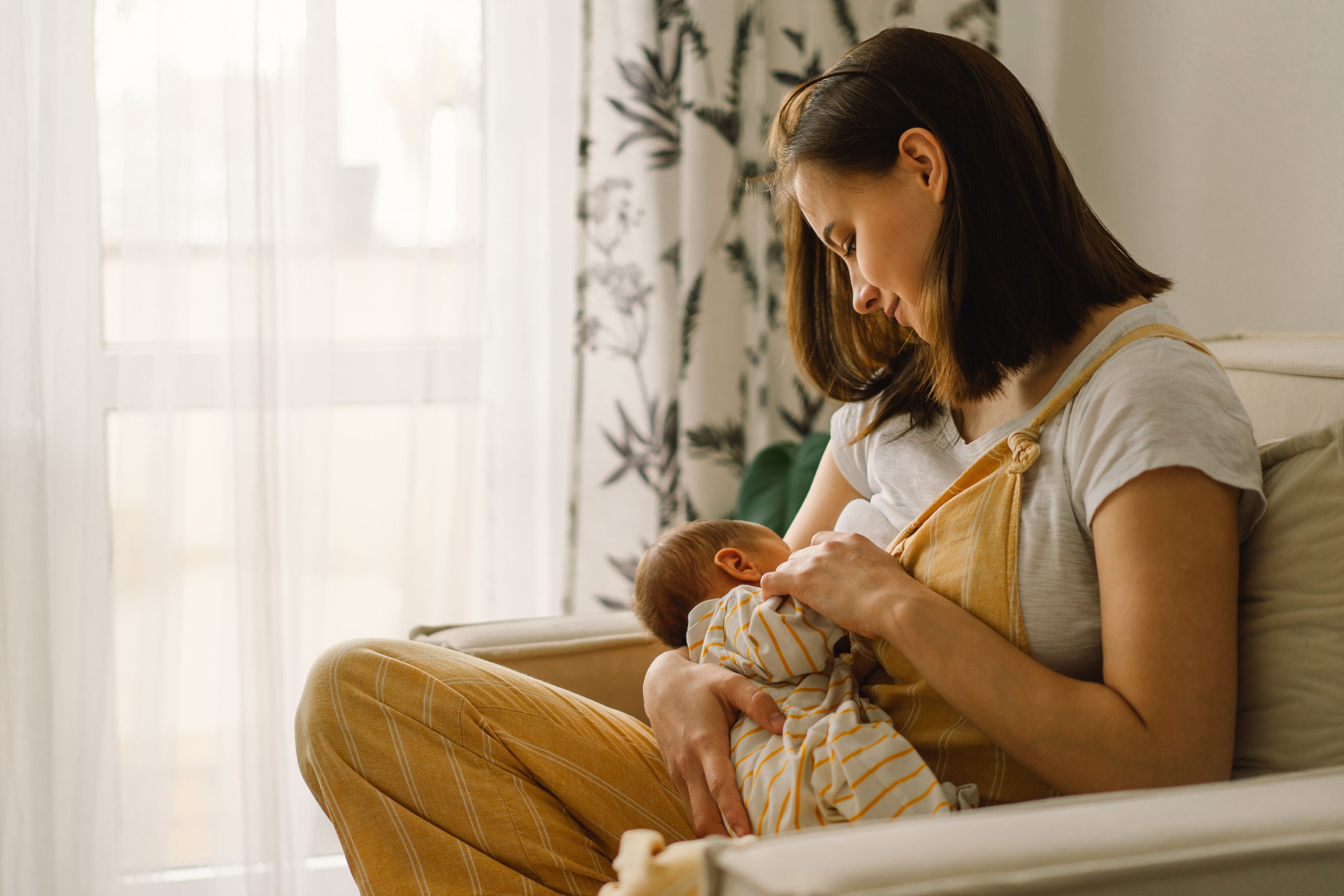 Milchstau behandeln: Junge Mutter stillt Neugeborenes