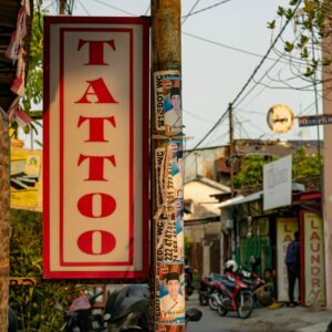 Leberentzündung:Werbung für ein Tattoostudio in geschäftiger Strasse im Sommer