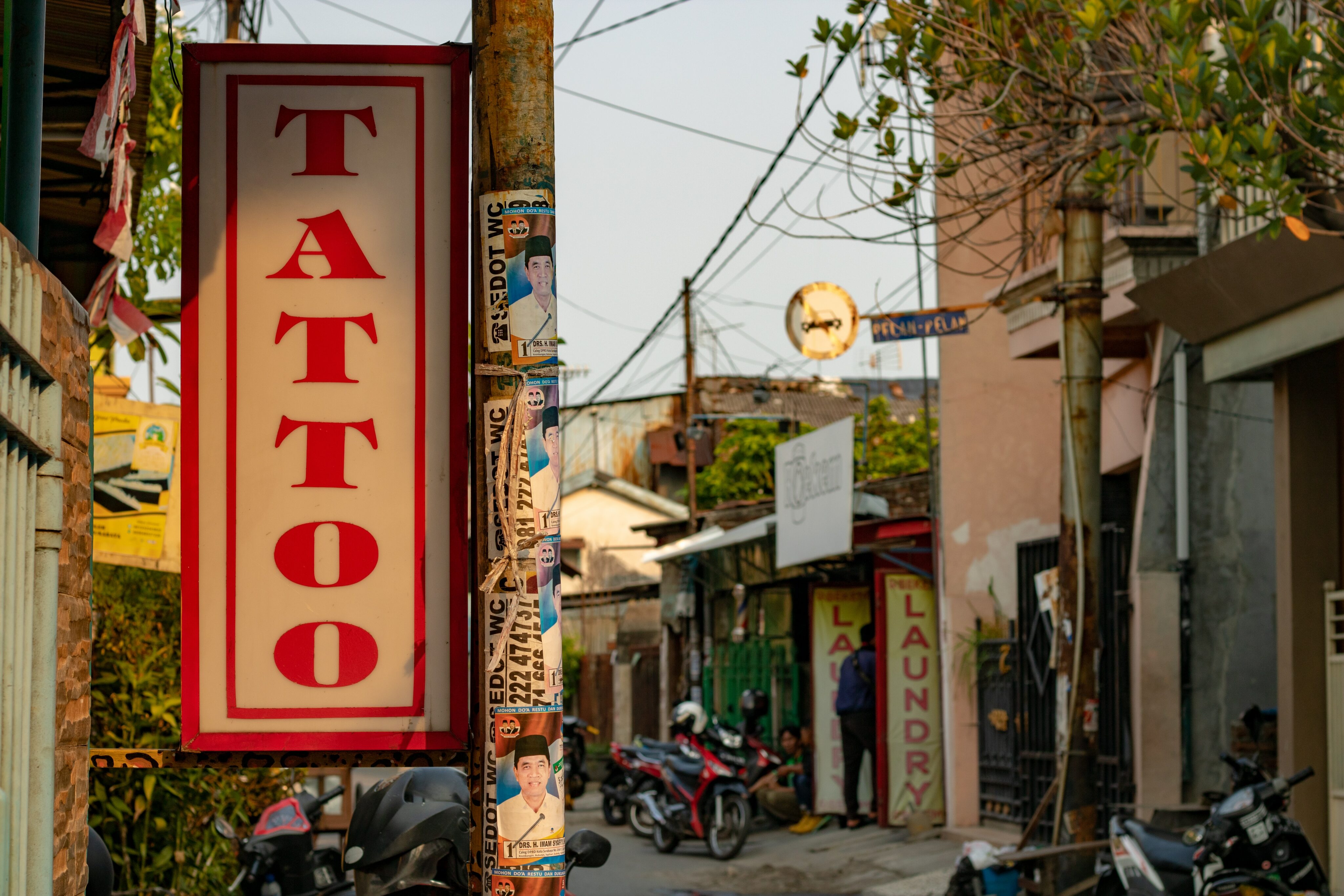 Leberentzündung:Werbung für ein Tattoostudio in geschäftiger Strasse im Sommer