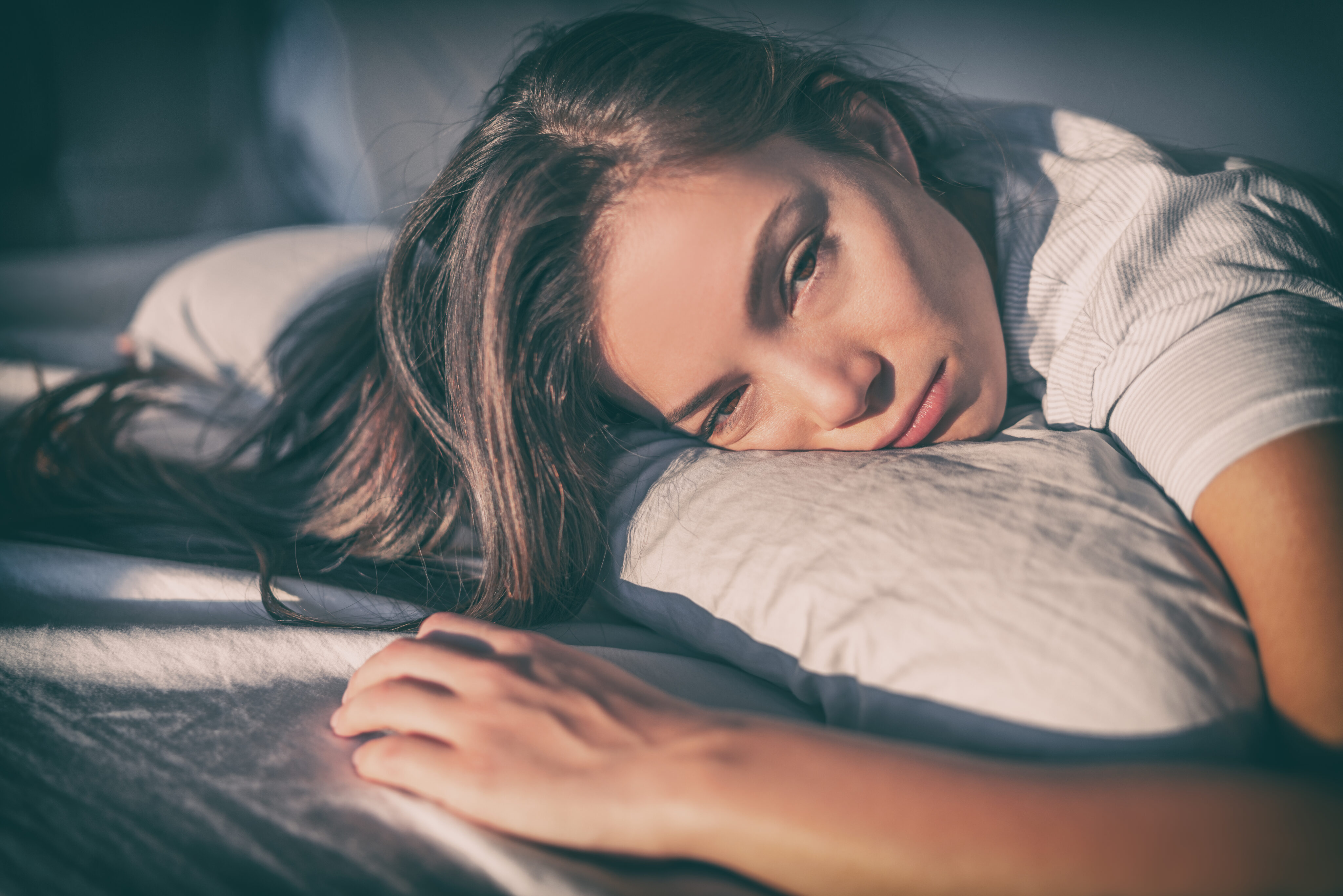 Fatigue-App: erschöpfte Frau liegt auf einem Kopfkissen