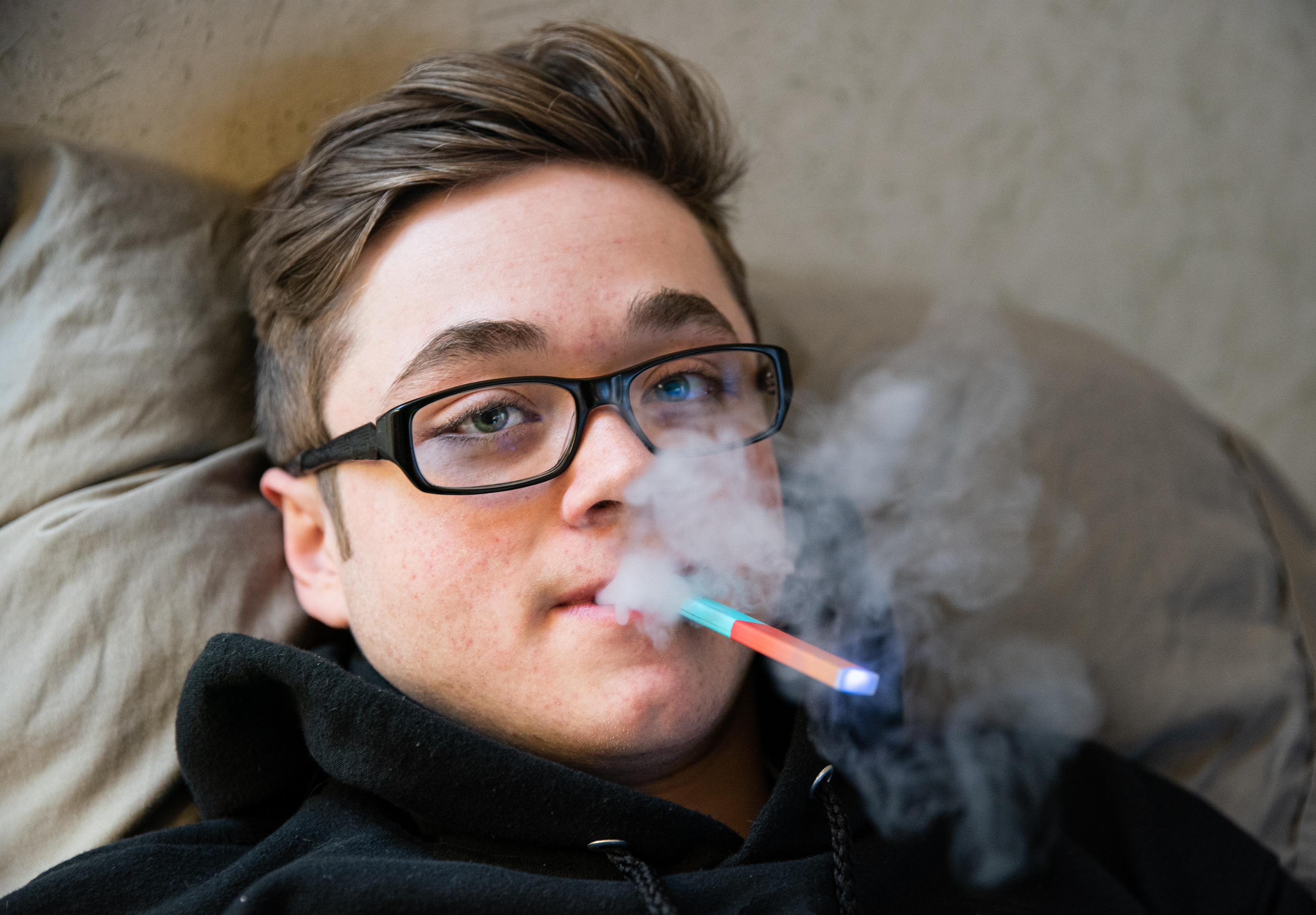Jugendliche vapen: Junge raucht E-Zigarette