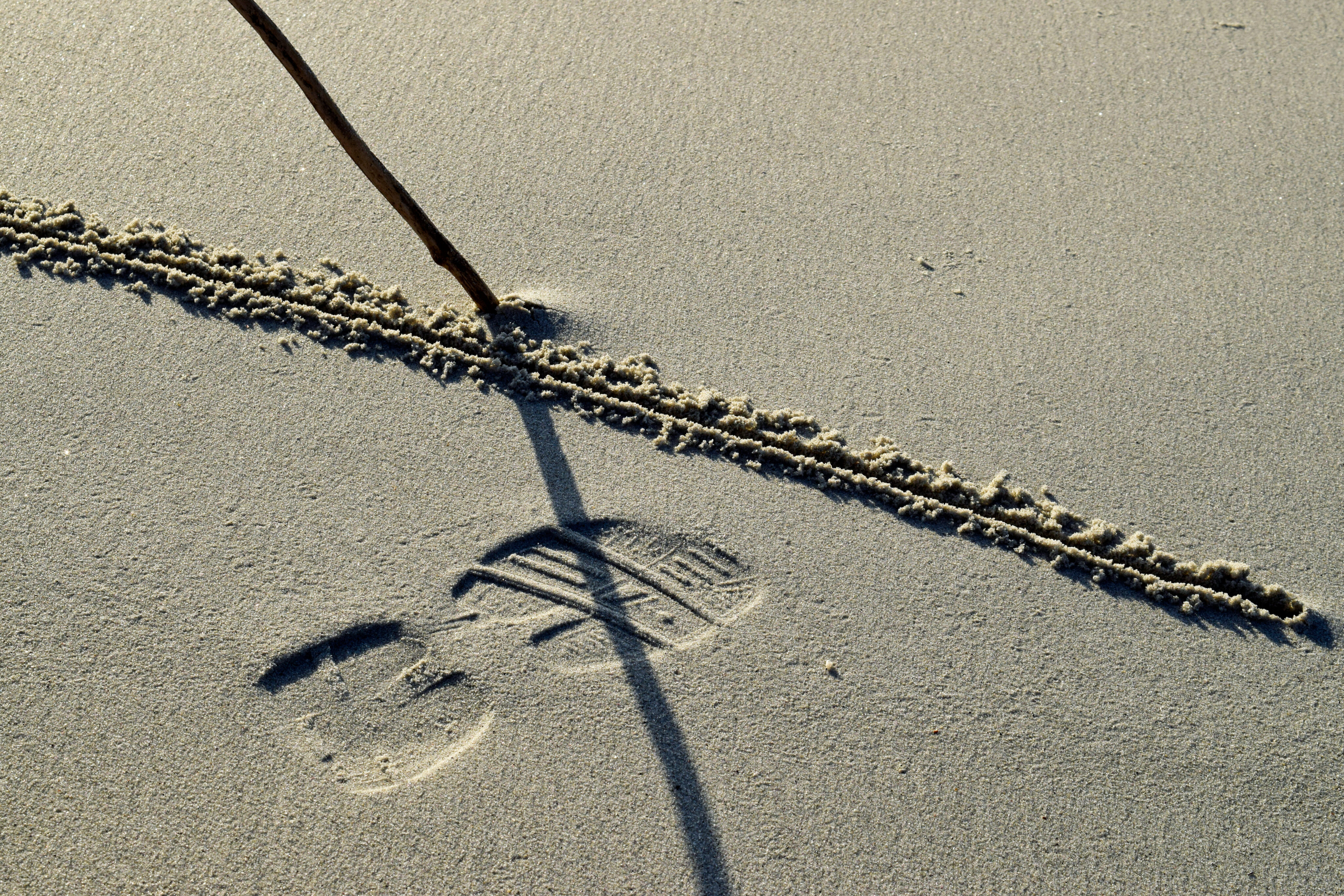 Fussabdruck mit gezogener Linie im Sand